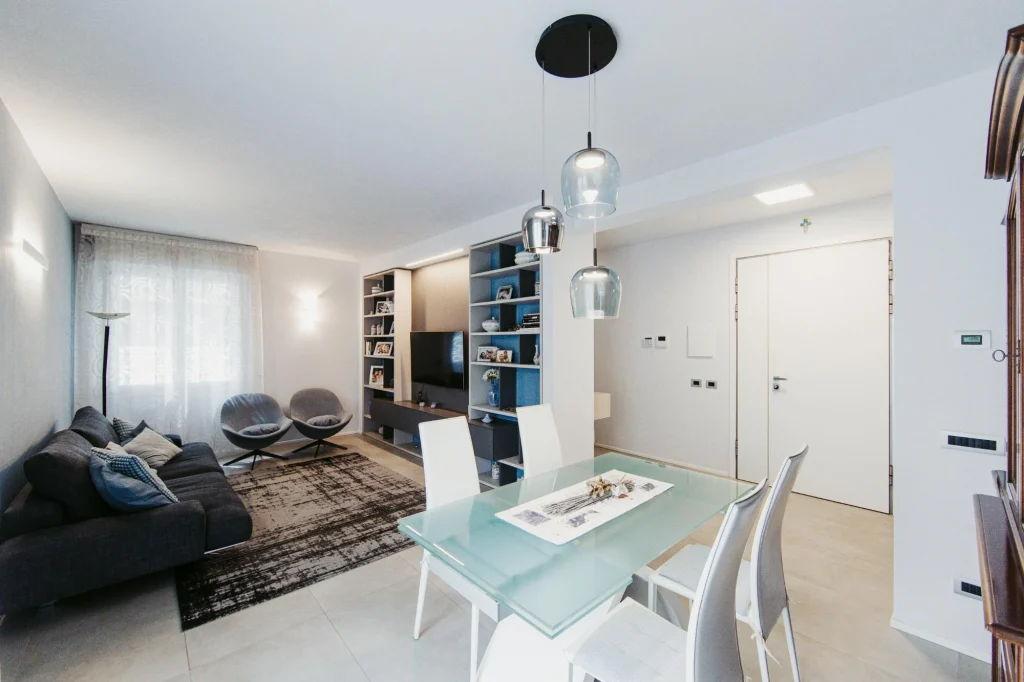 Sala con zona TV e libreria divisa dal corridoio con cartongesso.